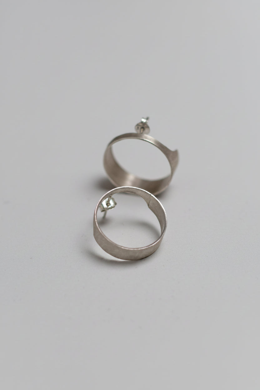 Silver hoop earrings on a light gray background