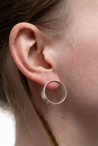 Close-up of a person wearing a silver hoop earring.