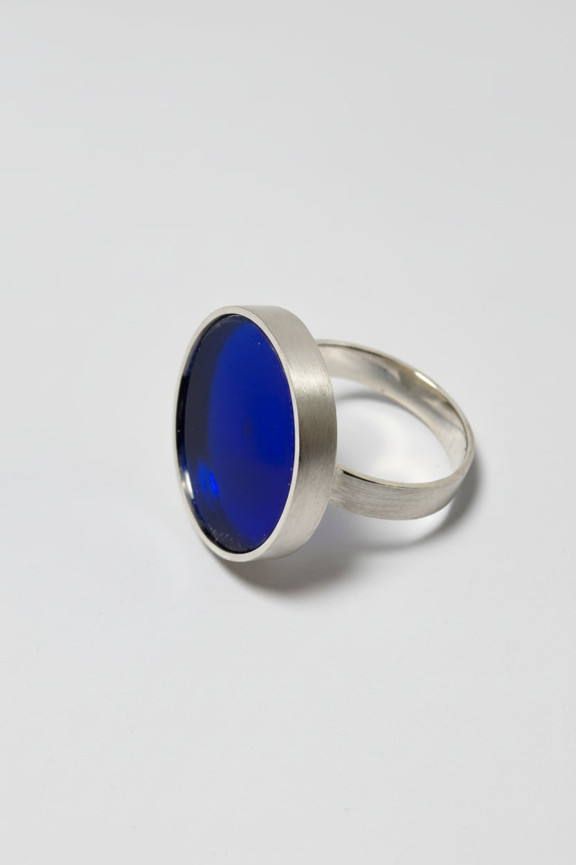 Silver ring with a blue acrylic on a gray background