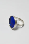 Silver ring with a blue acrylic on a gray background