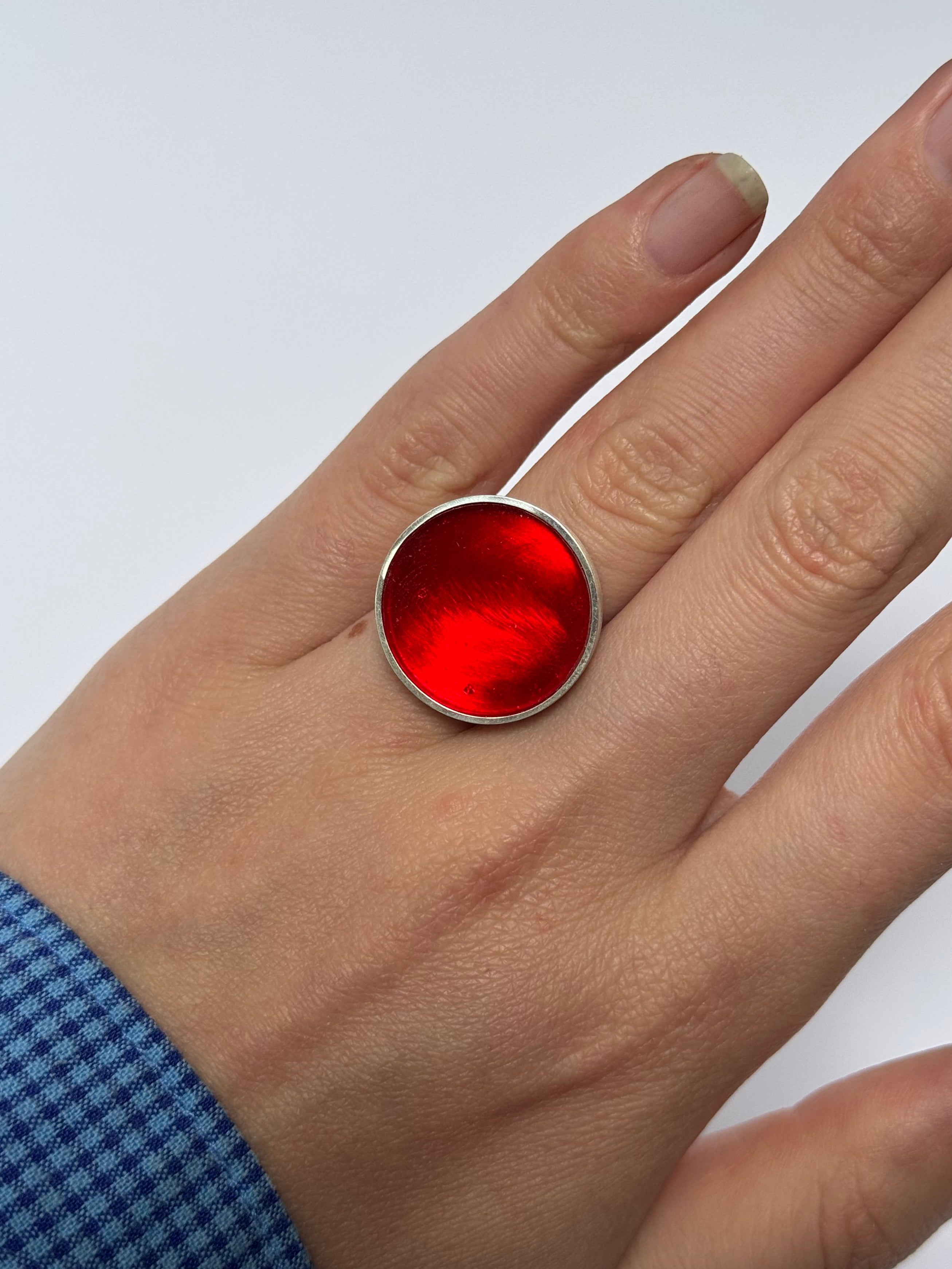Hand wearing a red ring with a white background