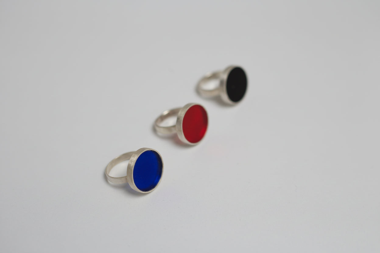 Three rings with colored acrylic on a light gray background