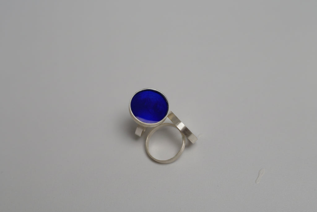 Silver ring with a blue gemstone on a gray background