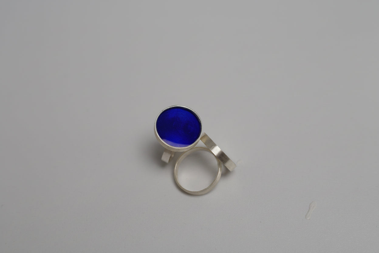 Silver ring with a blue gemstone on a gray background