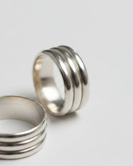 Two silver rings on a gray background